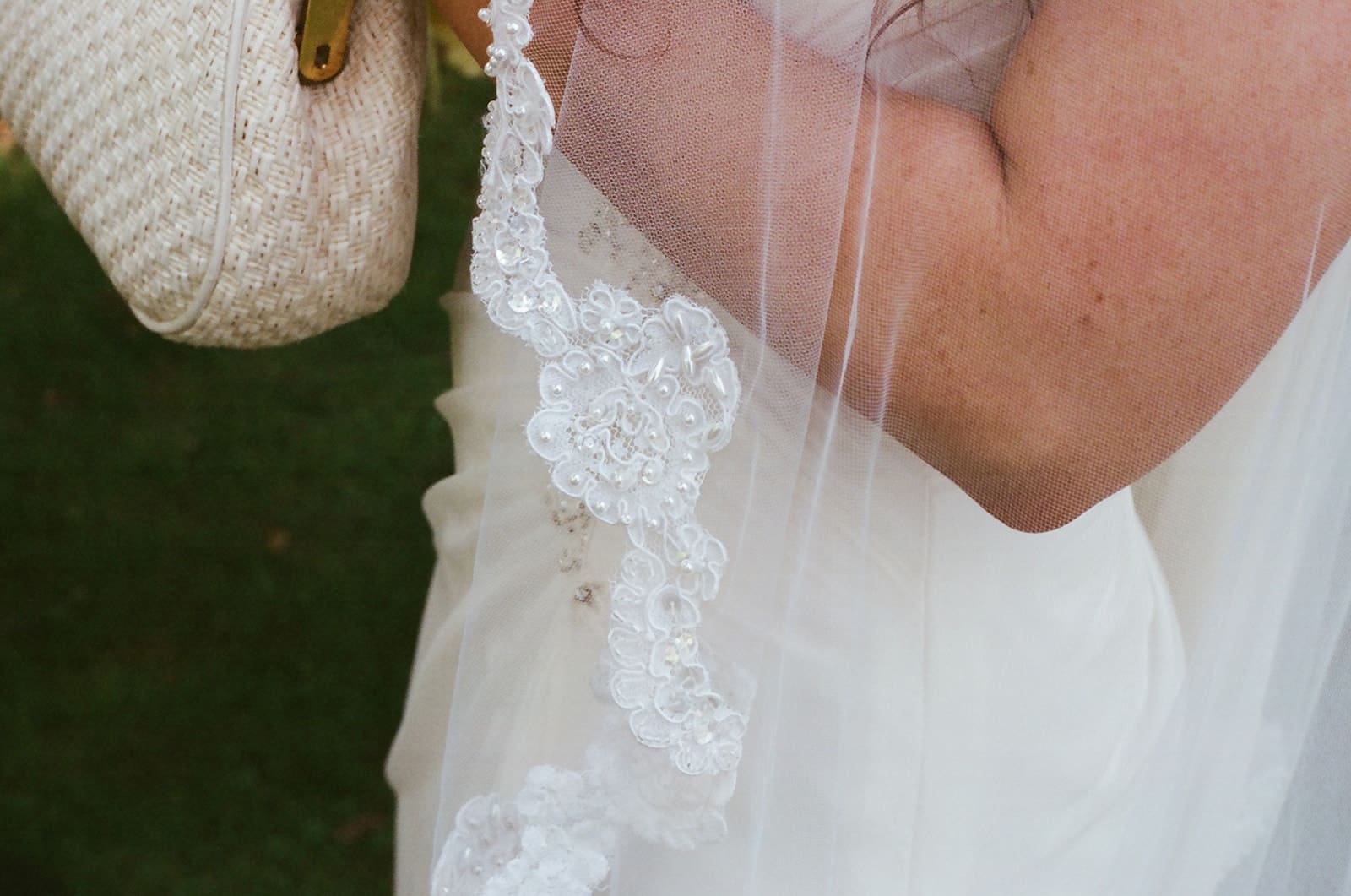Close-up of a bride’s lace wedding veil and white dress at Lakewold Gardens, photographed on CineStill 400D film.