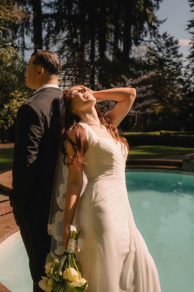 Bride and groom posing in front of the pool for their Lakewold Gardens wedding photos in Lakewood, Washington.