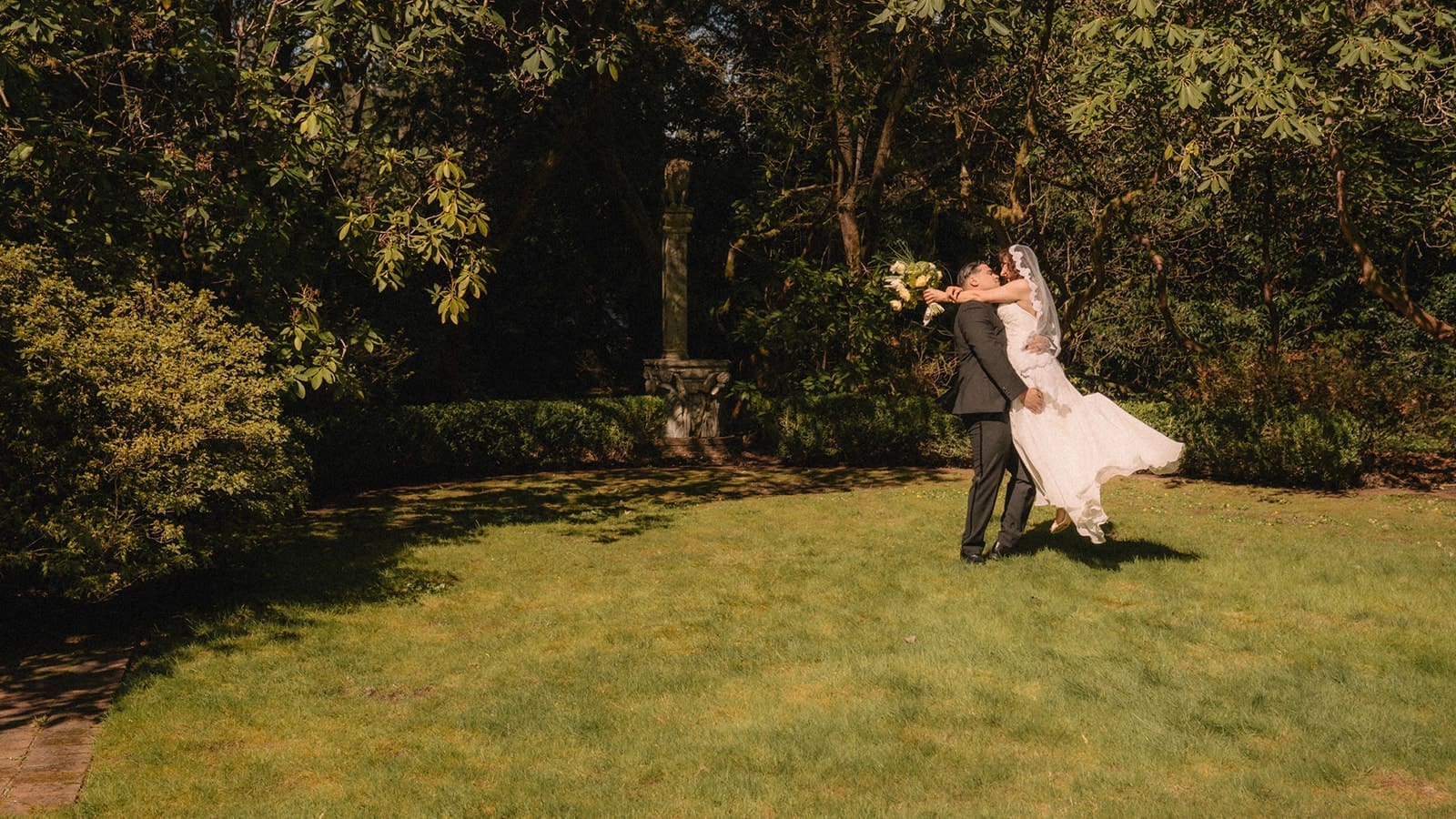 Groom lifting the bride during their Lakewold Gardens wedding photos.