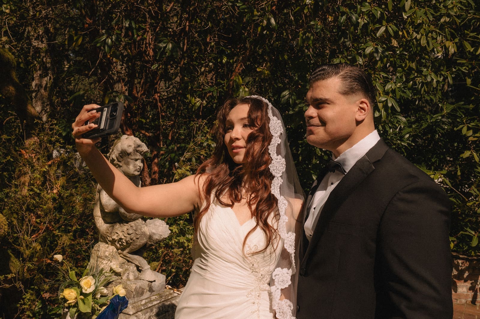 Bride and groom taking a selfie on their phone during their Lakewold Gardens wedding photos