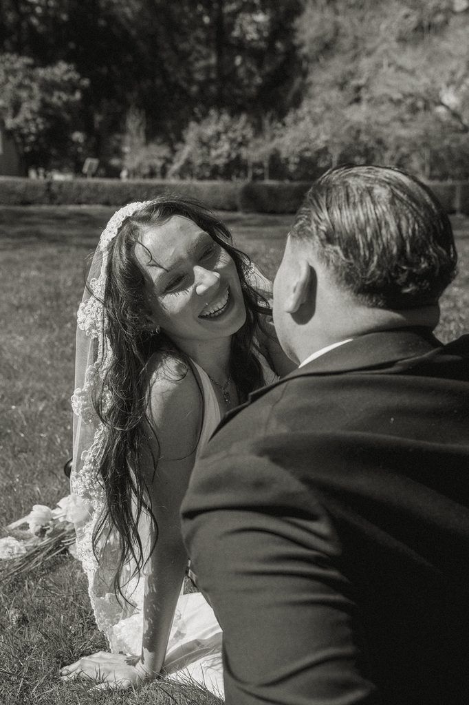 Black and white photo of a couple sitting in the grass.