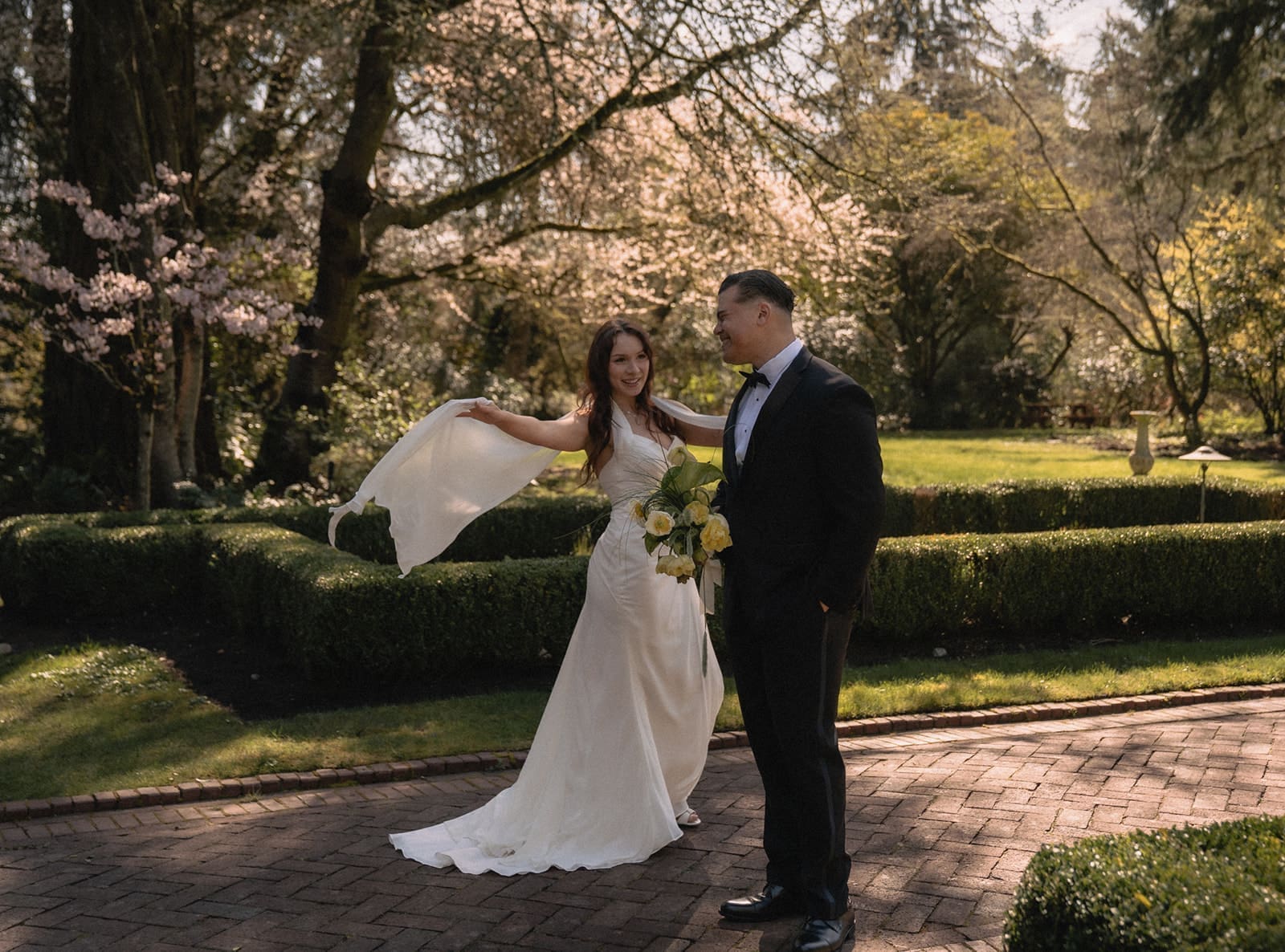 Bride and groom posing playfully in the gardens.
