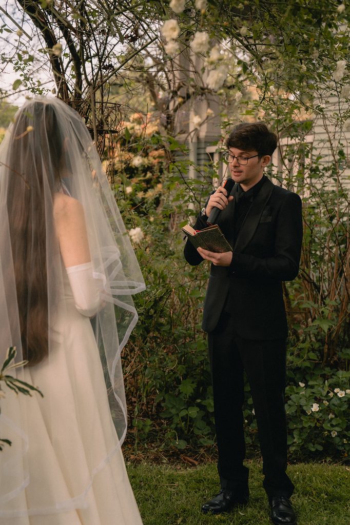 Groom reading his vows to the bride during their Seattle micro wedding ceremony at an Airbnb.