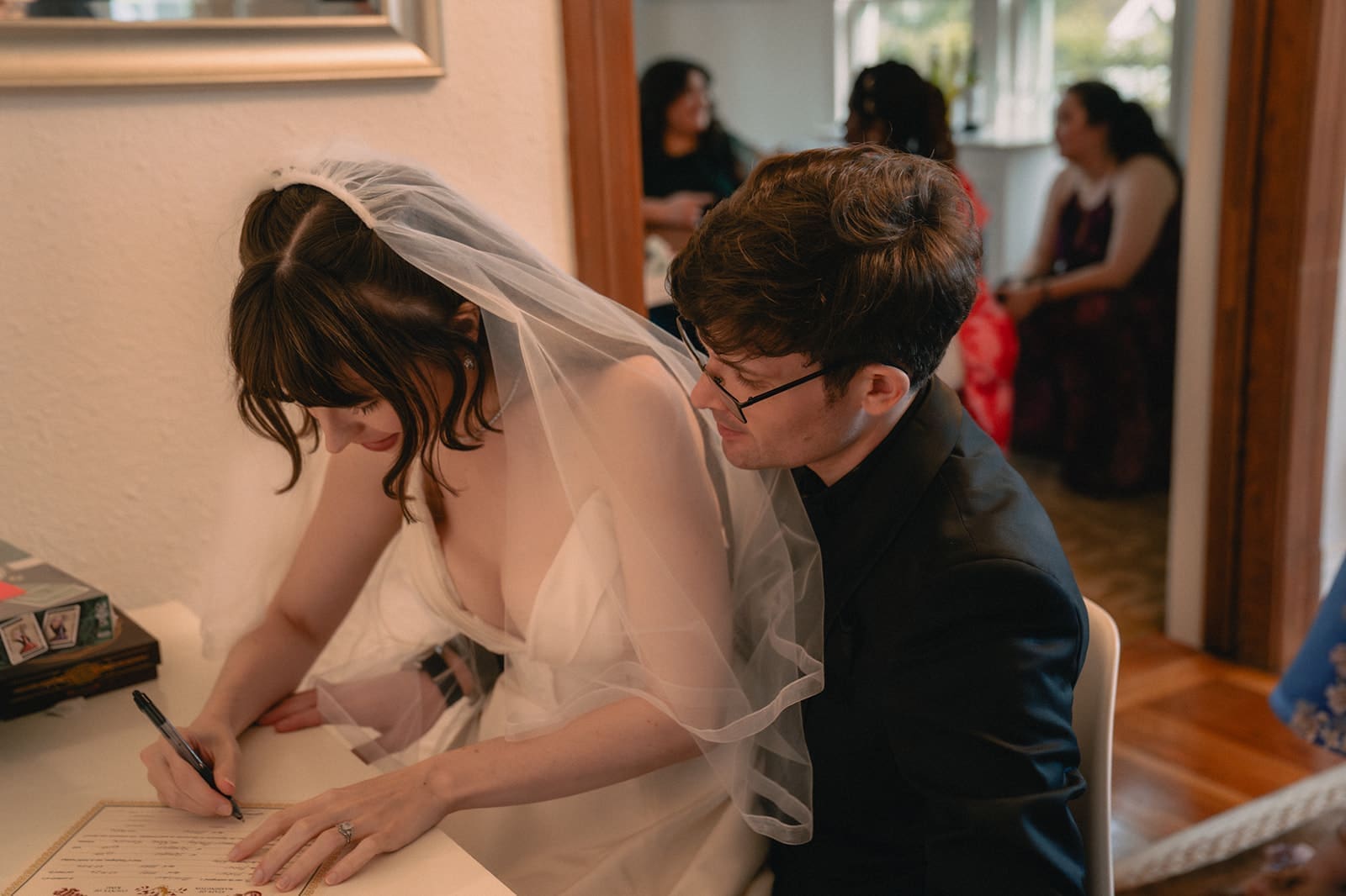 Bride signing the marriage license with the groom beside her after their Seattle micro wedding ceremony