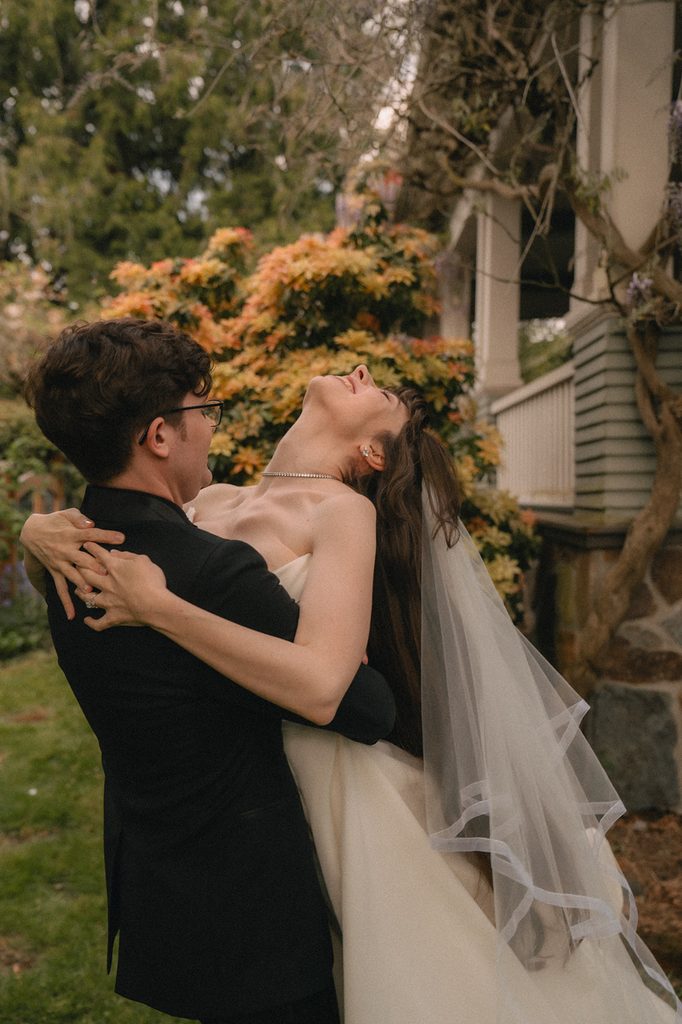 Groom lifting his bride during their outdoor portraits from a Seattle micro wedding at an Airbnb.