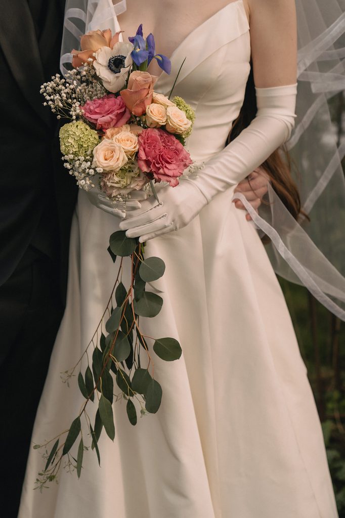 Close up shot of a bride holding a colorful wedding bouquet. 