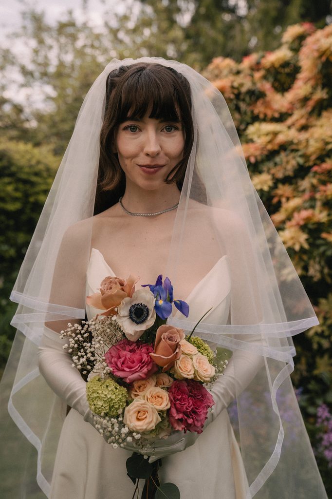 Bride holding a colorful wedding bouquet. 