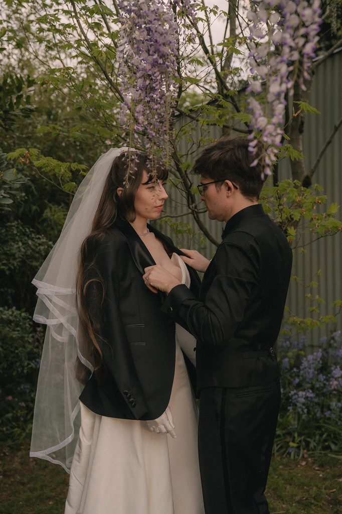 Groom putting a leather jacket on his bride during their outdoor portraits.
