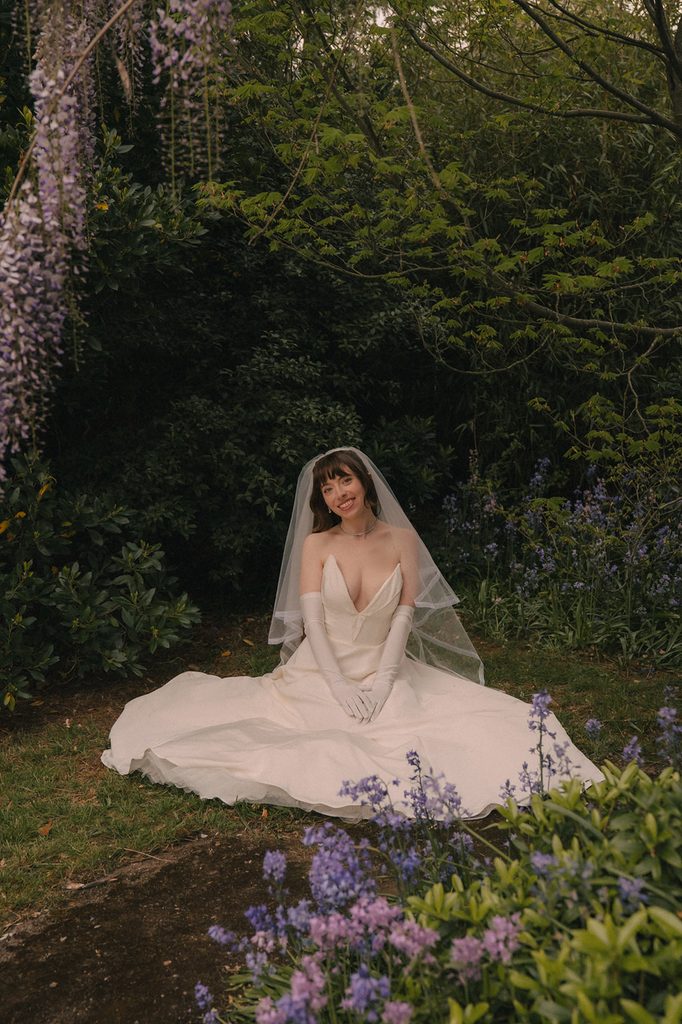 Bride knelling in the grass during her outdoor portraits. 