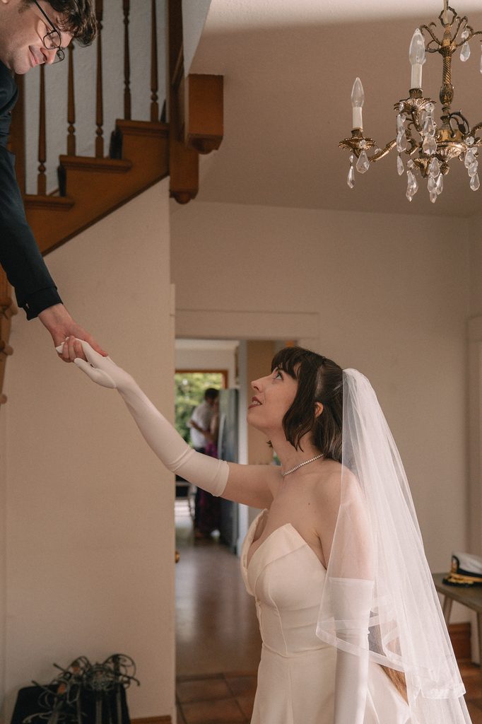 Groom helping the bride up the stairs.