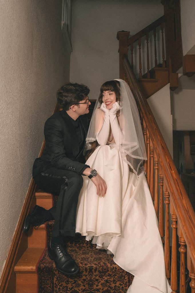 Bride and groom sitting and posing on the stairs for portraits. 