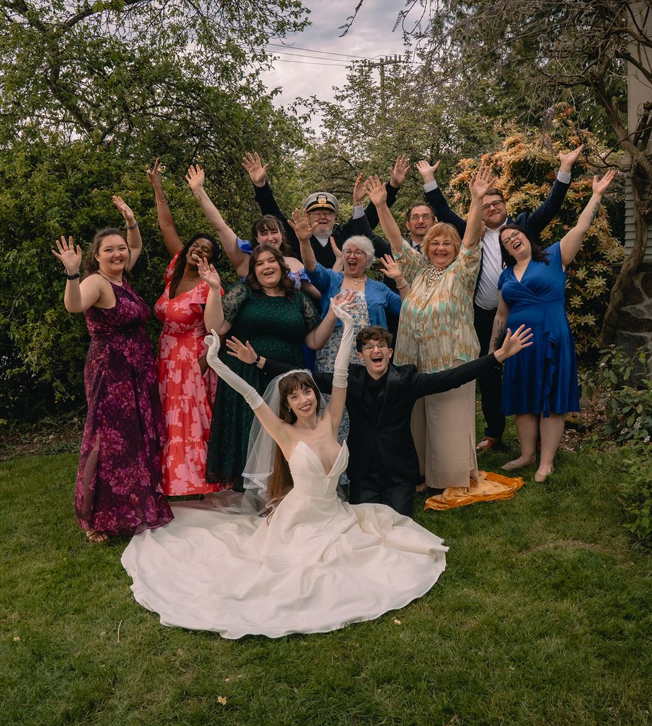 Outdoor photo of the bride, groom, and their friends and family. 