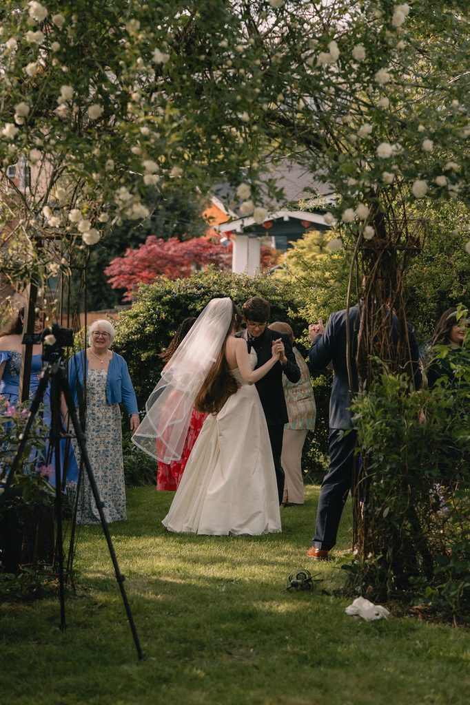 Bride and groom sharing a dance after the ceremony surrounded by family.