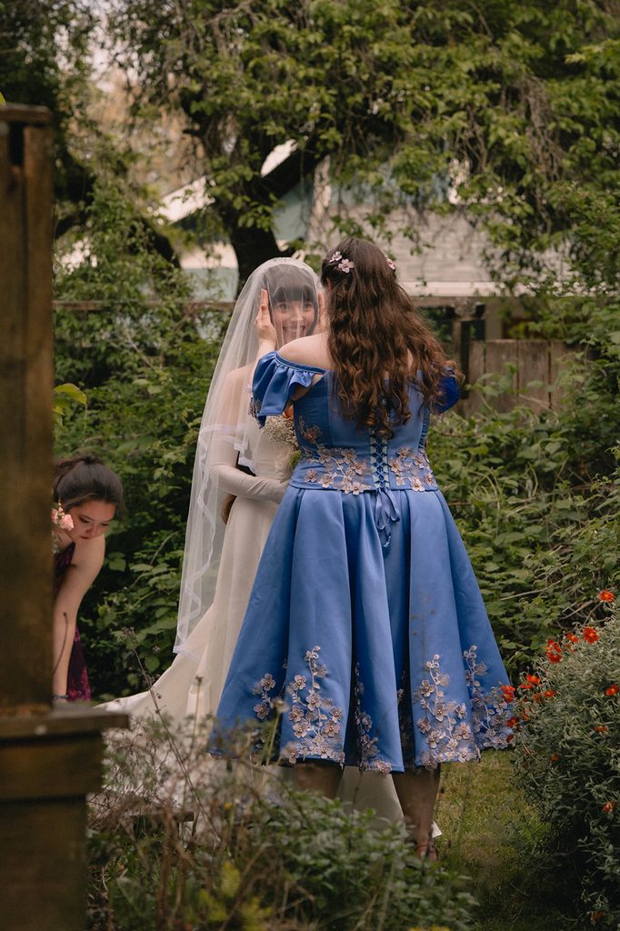 Bridesmaid talking to the bride before she goes to walk down the aisle.