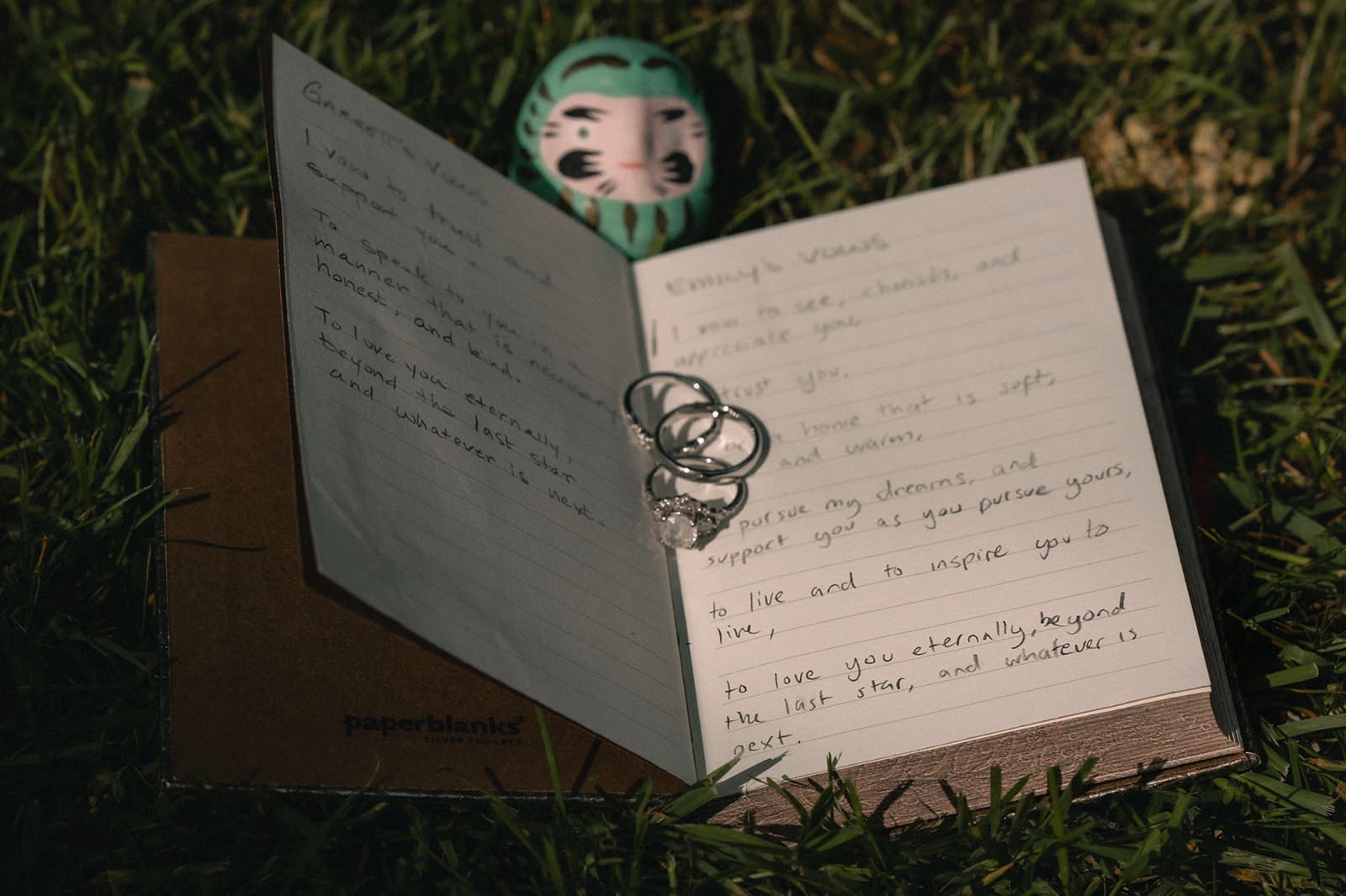 Wedding detail shot of bows and weddings rings in the grass. 